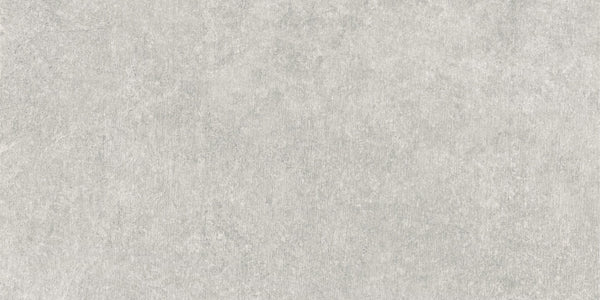 Revolve 12x24 Rectified Porcelain Tile features a light gray, stone-like surface with subtle shading variations and smooth, faint irregular patterns, giving it the contemporary look of concrete or natural stone.