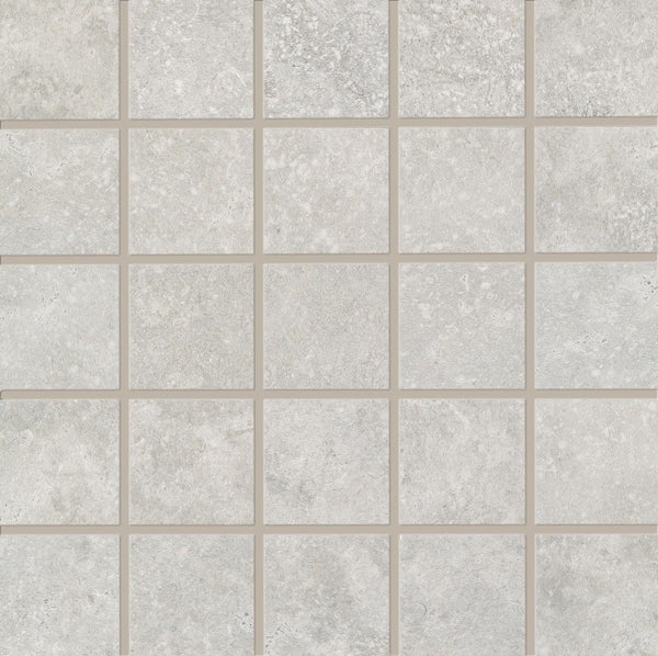 A grid of 25 light gray, stone-like Revolve 2x2 Mosaic Porcelain Tiles is arranged in five rows and five columns, each separated by thin beige grout lines for a decorative wall finish.
