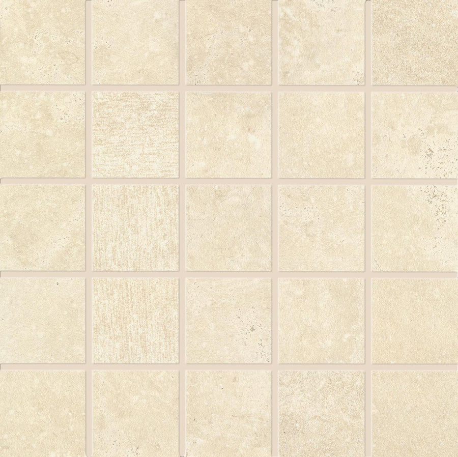The Revolve 2x2 Mosaic Porcelain Tile features a grid of square tiles with subtle textural and tonal variations, creating a simple, stone-like look. Thin, light-colored grout lines separate each tile for a natural stone appearance.