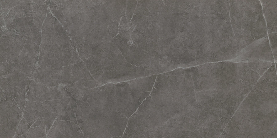 The Callie 12x24 Matte Porcelain Tile in Smoke features a dark gray surface with natural white veining and subtle texture, offering the elegant look of luxury stone.