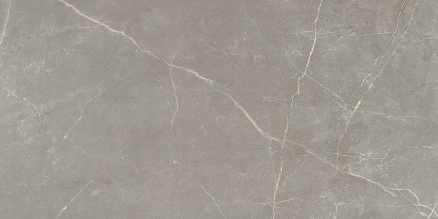 The Callie 12x24 Matte Porcelain Tile in Fog features a gray marble look with subtle white veining and natural stone texture, creating an elegant, smooth finish ideal for luxury countertops, floors, or wall applications.