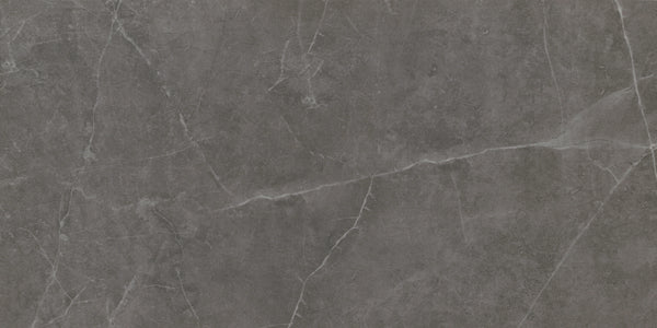 The Callie 12x24 Matte Porcelain Tile in Smoke features a dark gray surface with natural white veining and subtle texture, offering the elegant look of luxury stone.