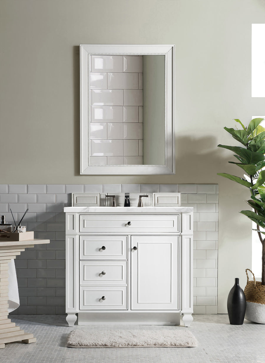 The Bristol 36" Vanity with a mirror, white tiled backsplash, black faucet, and drawers adds a fresh touch. A green potted plant sits to the right next to two woven baskets on a light gray patterned floor mat.