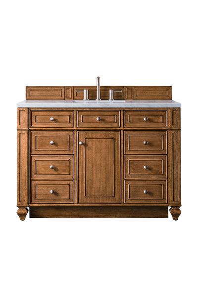 A wooden bathroom vanity with nine drawers, a central cabinet door, silver knobs, a white marble countertop, a built-in sink, and a modern faucet.