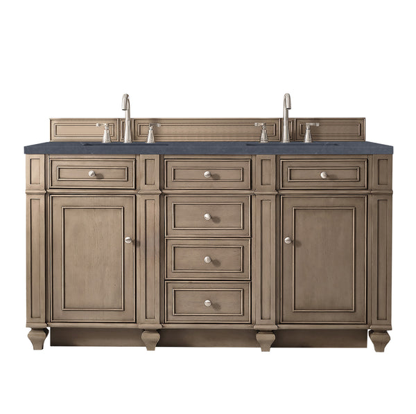 Double-sink bathroom vanity with a dark countertop, dual faucets, five central drawers, and four cabinet doors in a light wood finish, featuring silver handles and traditional panel detailing.