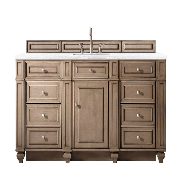 A wooden bathroom vanity with a white countertop, built-in sink, central cabinet door, and multiple drawers on both sides, all featuring matching round knobs. The faucet and hardware are metallic.