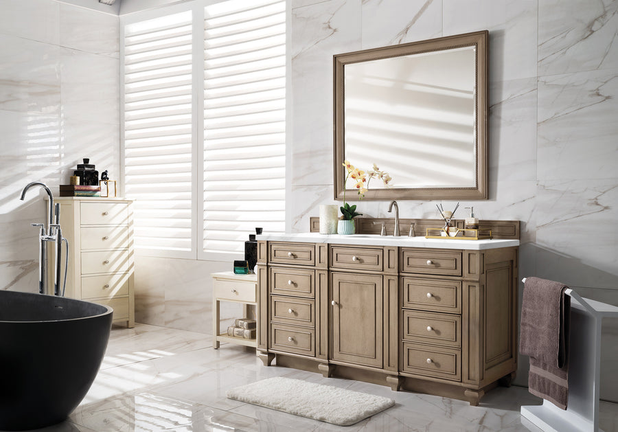Bright bathroom with marble walls, a large mirror above a wooden vanity, a black freestanding tub, a small cabinet, and a rug on the glossy floor. Sunlight streams through window shutters, casting shadows.