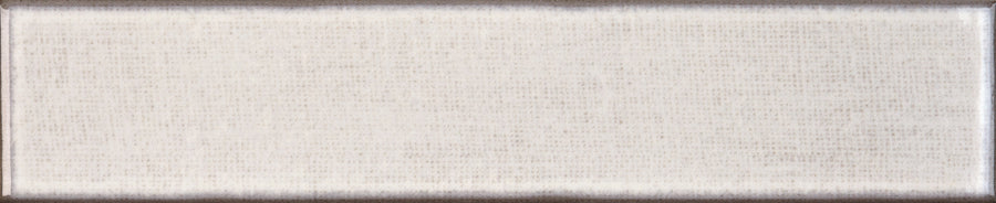 A rectangular Texstyle 2" x 10" Combed Subway Tile in Misty, featuring a fine grid pattern and slightly darker edges, lies flat on a neutral background resembling textured subway tile.