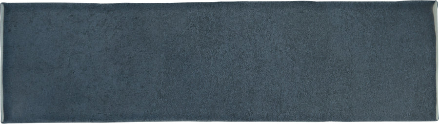 The Radiance 3" x 10" Glossy Subway Tile in Mariana, a rectangular dark gray tile with a textured finish, is displayed from above against a white background—ideal for kitchen backsplashes or accent walls.
