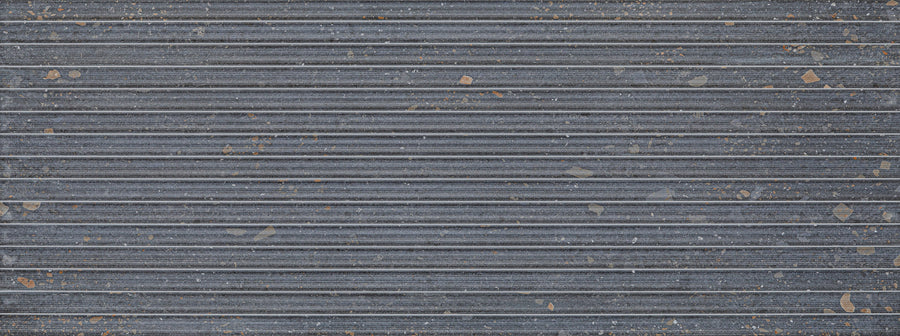 Close-up of Strata 18" x 48" Deco Tile in Ember, showing a corrugated linear surface with vertical grooves and a weathered grayish-blue hue accented by brown spots—ideal for feature walls or deco tile texture inspiration.