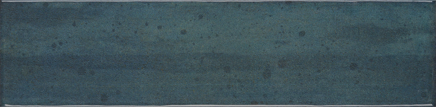 The Muse 4" x 16" Glossy Subway Tile in Azure features a rectangular shape with textured, deep blue-teal hues, subtle speckles, and irregular patterns for a modern, abstract wall accent.