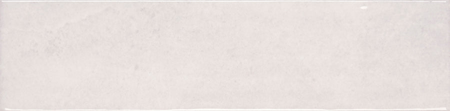 The Muse 4" x 16" Glossy Subway Tile in White Linen features a pale, textured surface with faint vertical lines, a slim white border, and a small white dot near the top right—evoking the look of premium contemporary wall tile.
