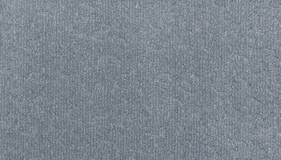 A close-up of Fleurious Pet Friendly Carpet shows its textured light blue surface with subtle patterns, offering luxurious comfort, a soft feel, and a slight sheen.