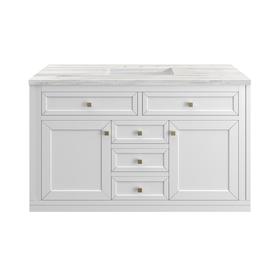 A white bathroom vanity with paneled cabinet doors, four central drawers, two side cabinets, and a marble countertop with an integrated sink. Gold square knobs accent the drawers and doors.