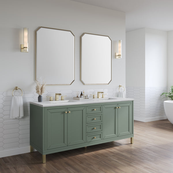 A modern bathroom with a sage green vanity, gold hardware, two rectangular mirrors, wall-mounted lights, white hexagonal tile backsplash, and wood flooring. A bathtub is partially visible on the right.