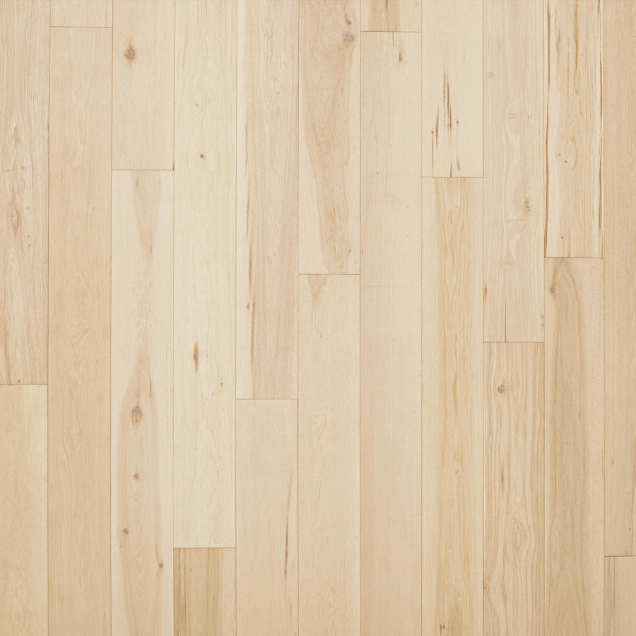 Rockford 7 1/2" Hickory Hardwood features light tones, visible natural grain, and subtle shade variations; luxurious planks are installed in a staggered pattern for an elegant look.