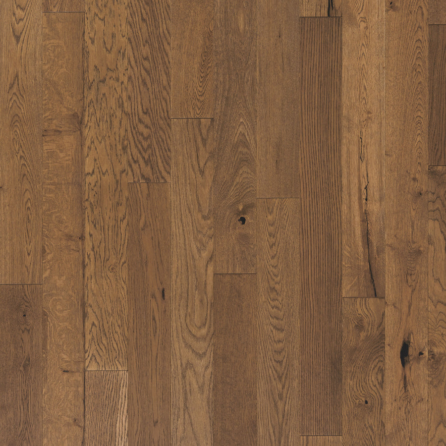 Close-up of Englewood White Oak 5" Hardwood flooring, showcasing medium brown tones, natural grain, and subtle knots. The engineered planks are laid in a staggered pattern for a classic, timeless appearance.