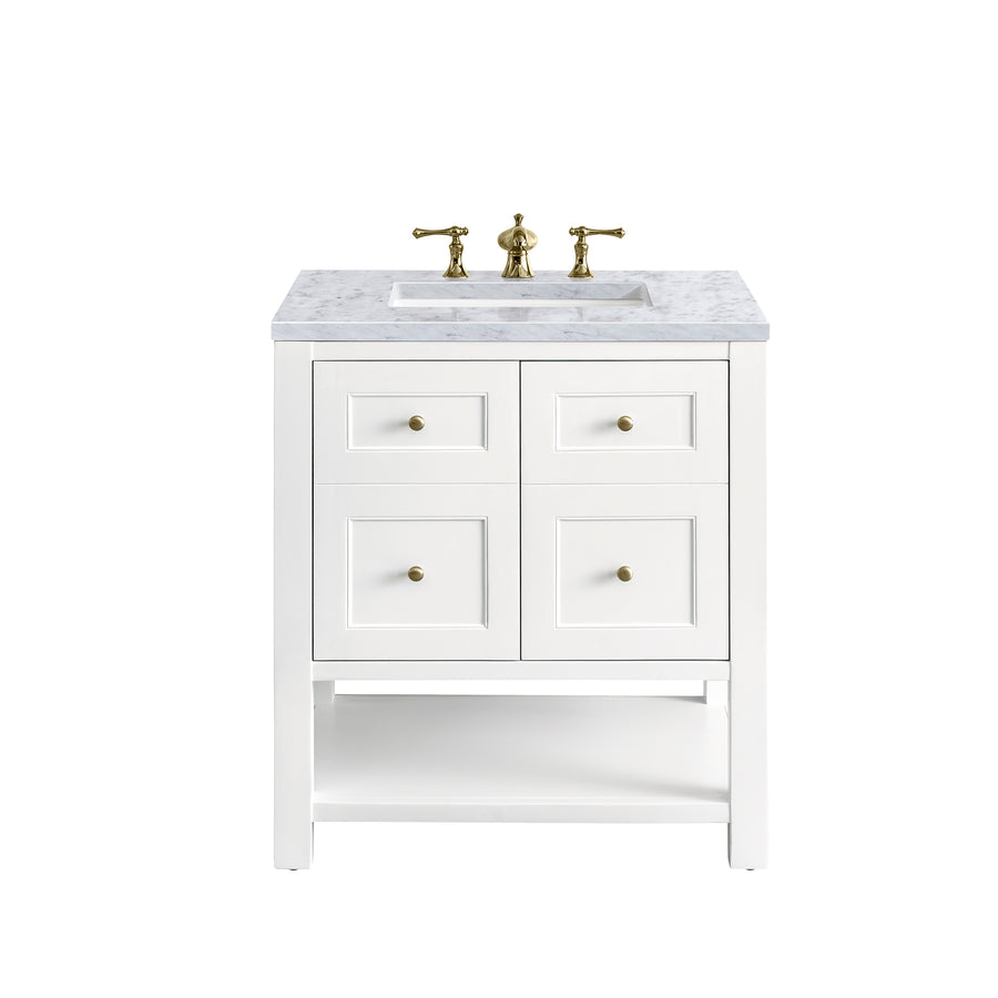 A white bathroom vanity with a marble countertop, gold faucet, and four drawers with gold knobs. The vanity has an open lower shelf and is set against a plain white background.