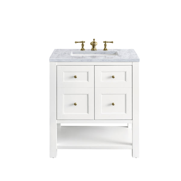 A white bathroom vanity with a marble countertop, gold faucet, and four drawers with gold knobs. The vanity has an open lower shelf and is set against a plain white background.