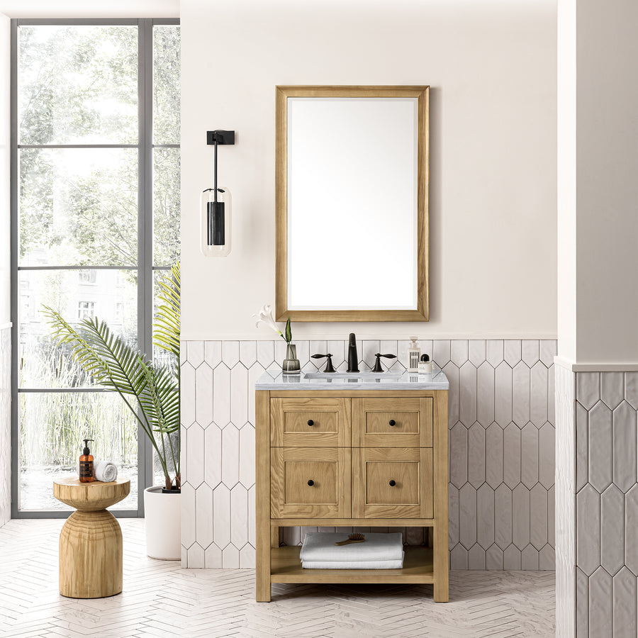 Modern bathroom with a Breckenridge 30" Vanity, marble countertop, and rectangular mirror. Hexagonal white tiles accent the lower wall. A potted plant, toiletries on a stool, and large window offer a fresh, airy transitional style.