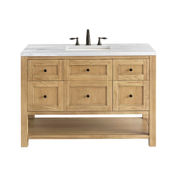 A wooden bathroom vanity with a white countertop, built-in sink, bronze faucet, six drawers, two cabinet doors, and an open lower shelf, photographed on a white background.