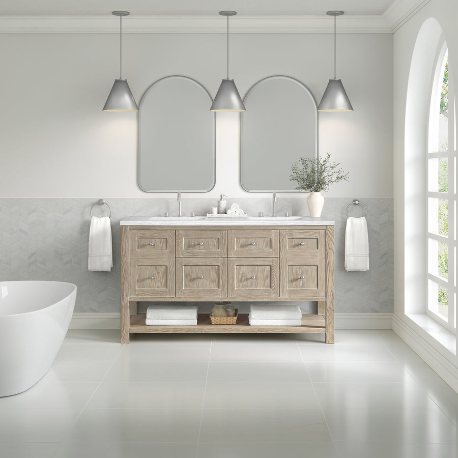 Modern bathroom featuring the Breckenridge 60" Double Bowl Vanity in light wood, two mirrors, three pendant lights, towels, a potted plant, freestanding bathtub, light-patterned walls, and a large arched window with natural light.