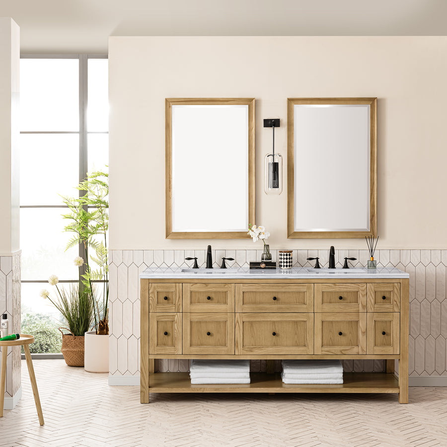 A modern bathroom showcases the Breckenridge 72" Double Bowl Vanity with two rectangular mirrors, black fixtures, potted plants, and rolled towels. White tile walls and a large window fill this transitional space with natural light.