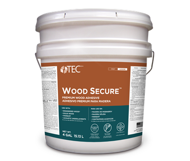 A large white plastic bucket labeled TEC Wood Secure, a premium wood flooring adhesive for installation and hollow spot repair, featuring product info in English and Spanish and a metal handle, set on a plain light background.