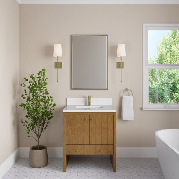 Modern luxury bathroom featuring the Hudson 30″ Vanity in Honey Oak, complemented by gold fixtures, a wall-mounted mirror, two sconces, a potted plant, towel ring, and a window with views of green trees outside. The space has neutral walls and a patterned tile floor.