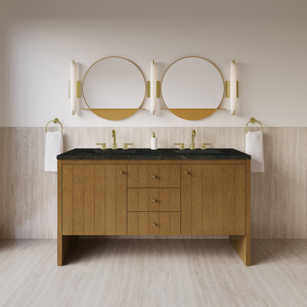 Modern bathroom featuring the Hudson 60″ Double Bowl Vanity in Honey Oak, topped with a black countertop and complemented by two round mirrors. Vertical lights flank each mirror, while towel rings are mounted at both ends. The space blends luxury and functionality, with walls half-tiled in light stone for an elegant finish.