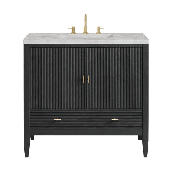 Black bathroom vanity with fluted double doors, a lower drawer, gold handles, and a white marble countertop featuring a gold faucet and handles.