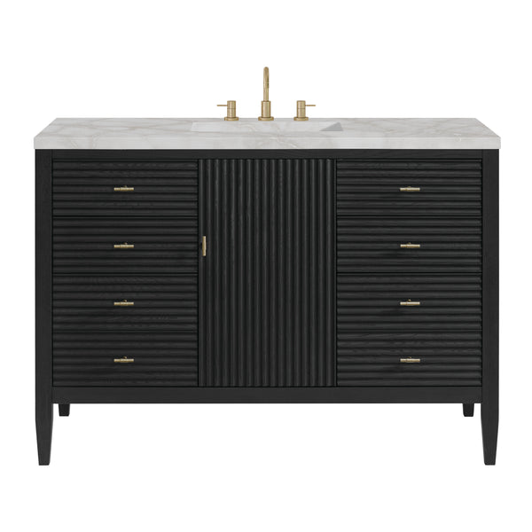 A modern black bathroom vanity with gold hardware, a ribbed central cabinet, six drawers on each side, a white marble countertop, and a gold faucet.