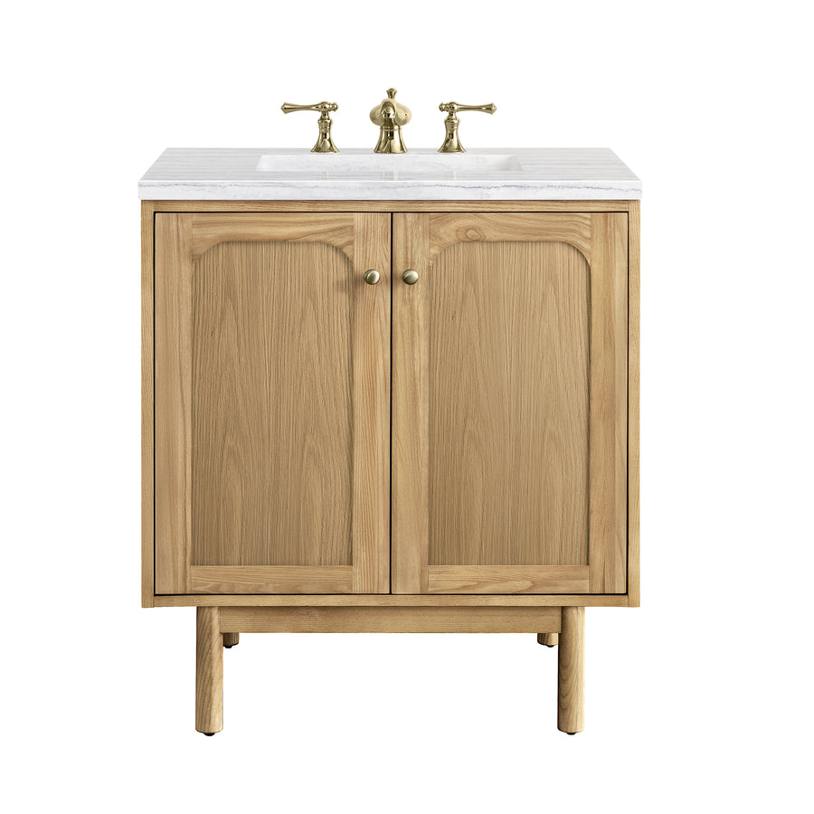 A wooden bathroom vanity with two cabinet doors, brass knobs, a white countertop, and brass faucet fixtures, photographed against a white background.