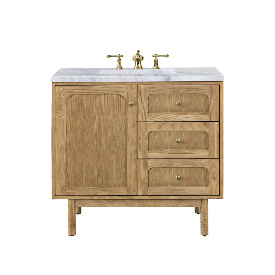 Wood bathroom vanity with a white marble countertop, brass faucet, one cabinet door on the left, and three drawers on the right, all featuring brass knobs. The vanity has a mid-century modern design.