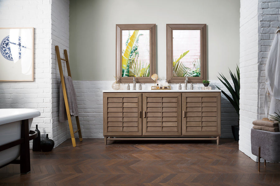 The modern bathroom features the Portland 72" Double Bowl Vanity with double sinks and ample storage, complemented by two mirrors, greenery, a towel ladder, white brick walls, and a freestanding tub in a bright, natural setting.