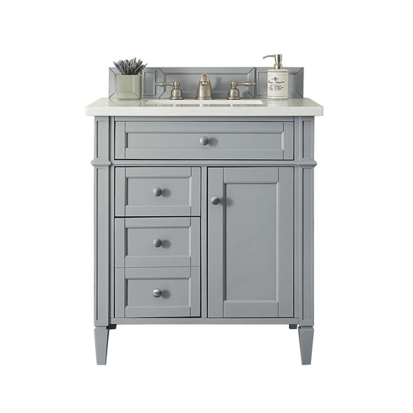 A gray bathroom vanity with a white countertop, under-mount sink, silver faucet, three drawers, one cabinet, a soap dispenser, and a container with brushes, all against a white background.