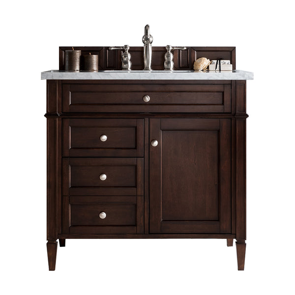 Dark wood bathroom vanity with a marble countertop, silver faucet, three drawers on the left, a cabinet door on the right, and decorative items including towels and a soap dish on top.