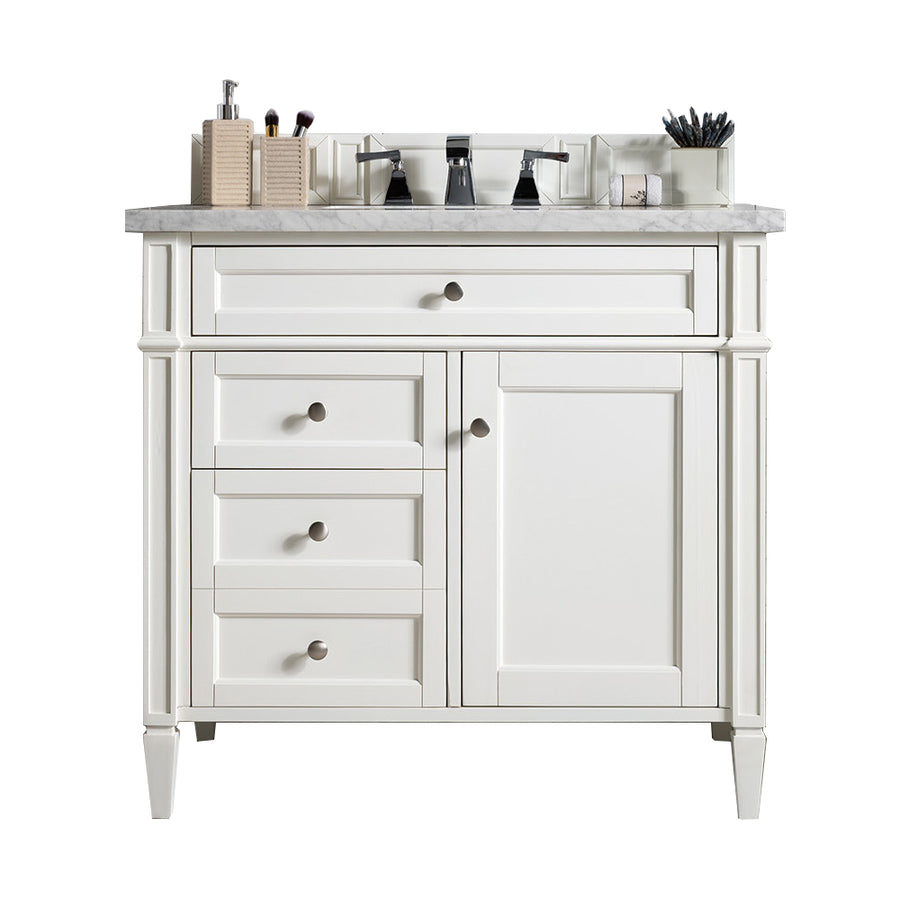 A white bathroom vanity with a marble countertop, three drawers, one cabinet door, and a sink. Items like makeup brushes and containers are neatly arranged on the countertop.