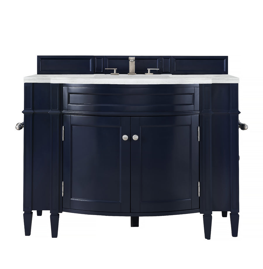 A navy blue bathroom vanity with a white countertop, silver faucet, two cabinet doors, side panels, and silver handles, shown against a white background.