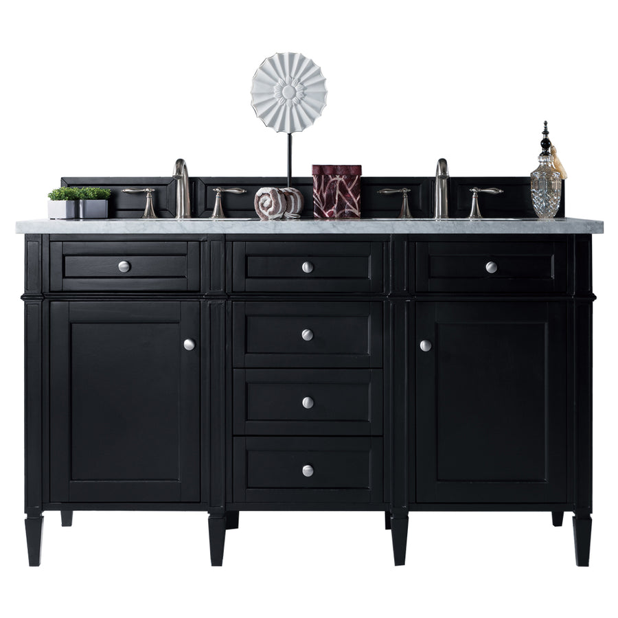 A black double-sink bathroom vanity with silver handles, a white countertop, and two faucets. Decorative items, including a plant, soap dispenser, and modern sculpture, are arranged on top.