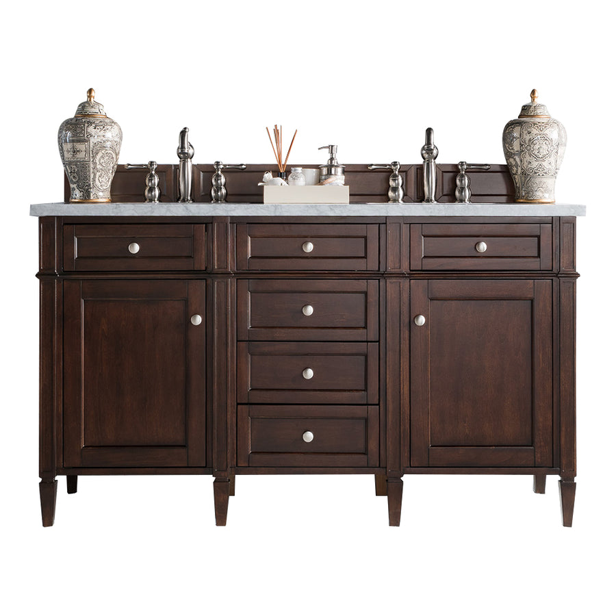A dark wood bathroom vanity with silver knobs, a marble countertop, two patterned ceramic vases, and various bathroom accessories, isolated on a white background.