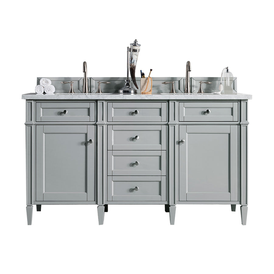 A gray double-sink bathroom vanity with silver faucets, a marble countertop, drawers and cabinets, and bathroom accessories like towels, a soap dispenser, and a toothbrush holder.