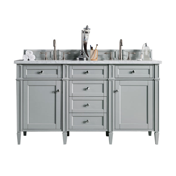 A gray double-sink bathroom vanity with silver faucets, a marble countertop, drawers and cabinets, and bathroom accessories like towels, a soap dispenser, and a toothbrush holder.