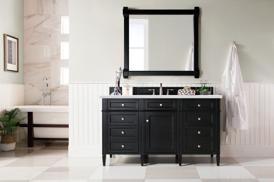 A modern bathroom showcases the Brittany 60" Vanity with double sinks, a large mirror, white wall paneling, towel rack with robes, a nearby bathtub and plant. Light-tiled floors enhance the space’s fresh look.
