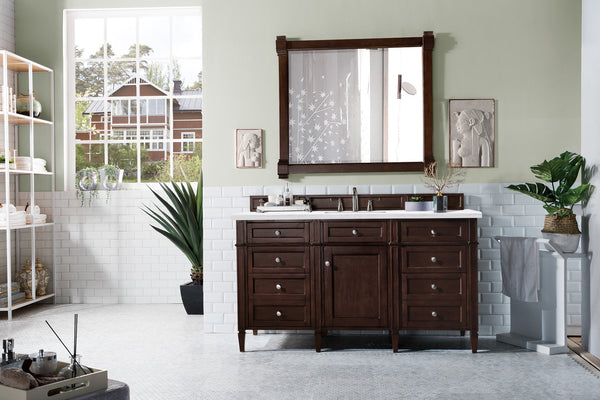 A bright bathroom features a large window, double sinks on the Brittany 60