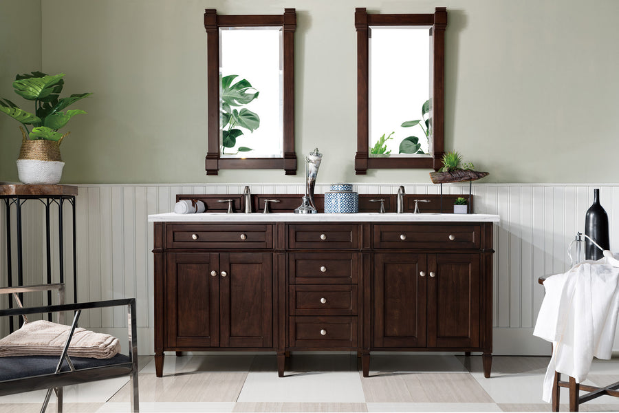 A modern bathroom highlights the Brittany 72" Double Bowl Vanity in dark wood, flanked by two rectangular mirrors, with potted plants and neutral walls. Towels and accessories are neatly arranged on and around the vanity.