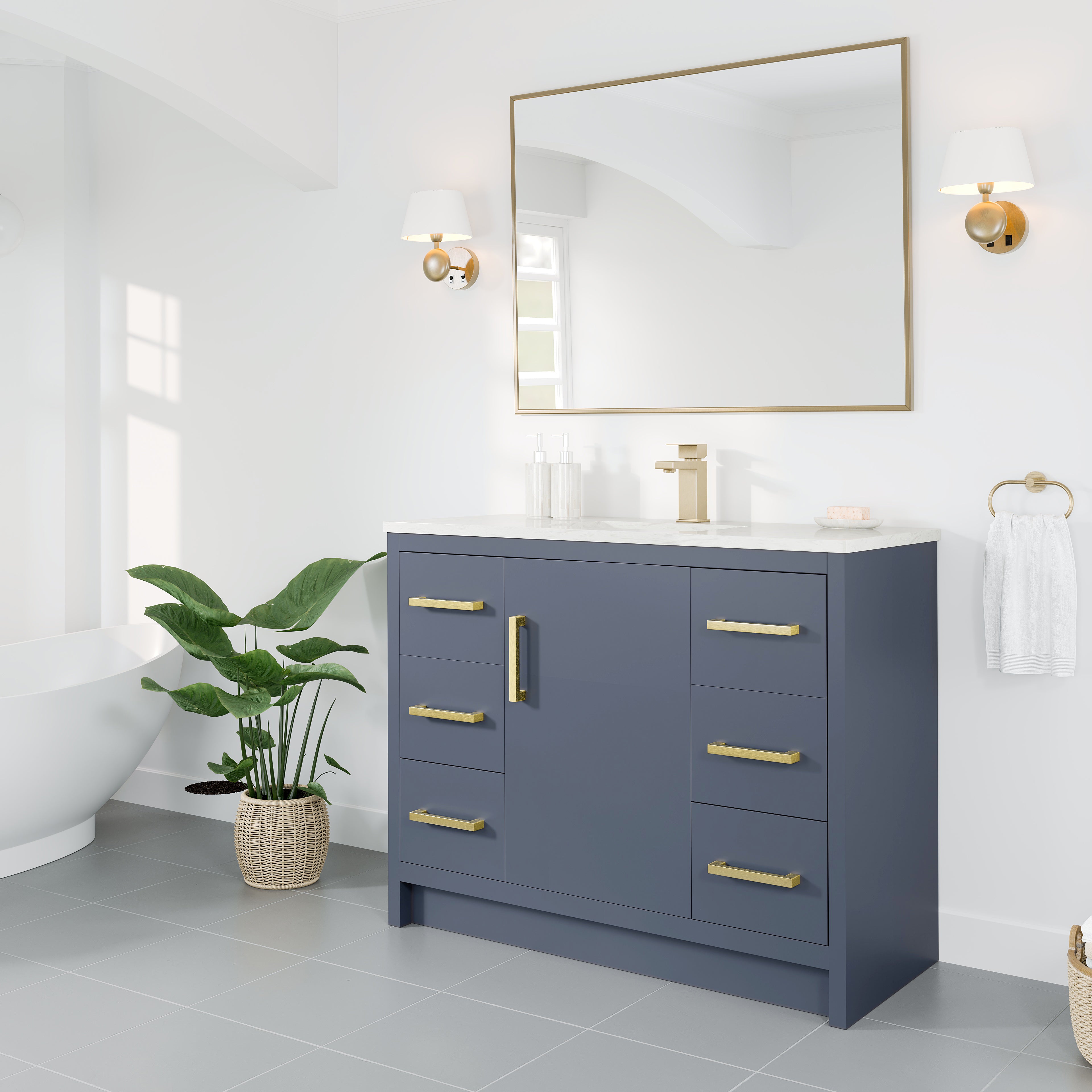 
		                            	A modern bathroom with a navy blue vanity, gold hardware, a large mirror, wall sconces, a potted plant, a towel ring, and a freestanding bathtub in a bright, white space.
		                            