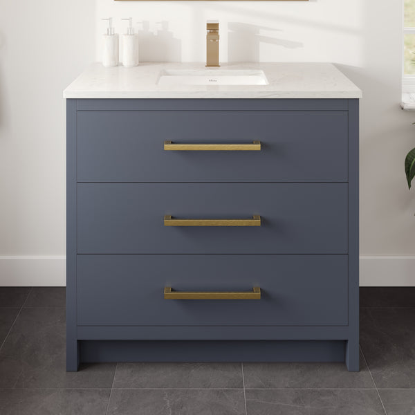 The Curio 36″ Vanity in Dark Blue features a sleek Carrara quartz top with an integrated sink, complemented by a gold faucet and elegant gold handles. Three soap dispensers on the left add practicality, while the vanity stands on a dark gray tile floor for a stylish and contemporary look.