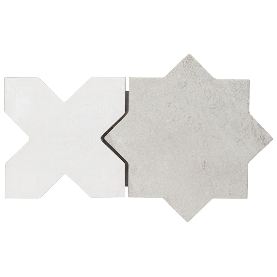 A matte X-shaped tile in light matte white pairs with the Morocco Star & Cross Porcelain Tile in grey, both featuring subtle texture, placed side by side on a white background.