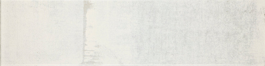The Urban Glow 4" x 16" Subway Tile in Lunar features a subtle, faded gradient in light gray and off-white with a lightly textured surface and soft vertical discoloration on the left side.